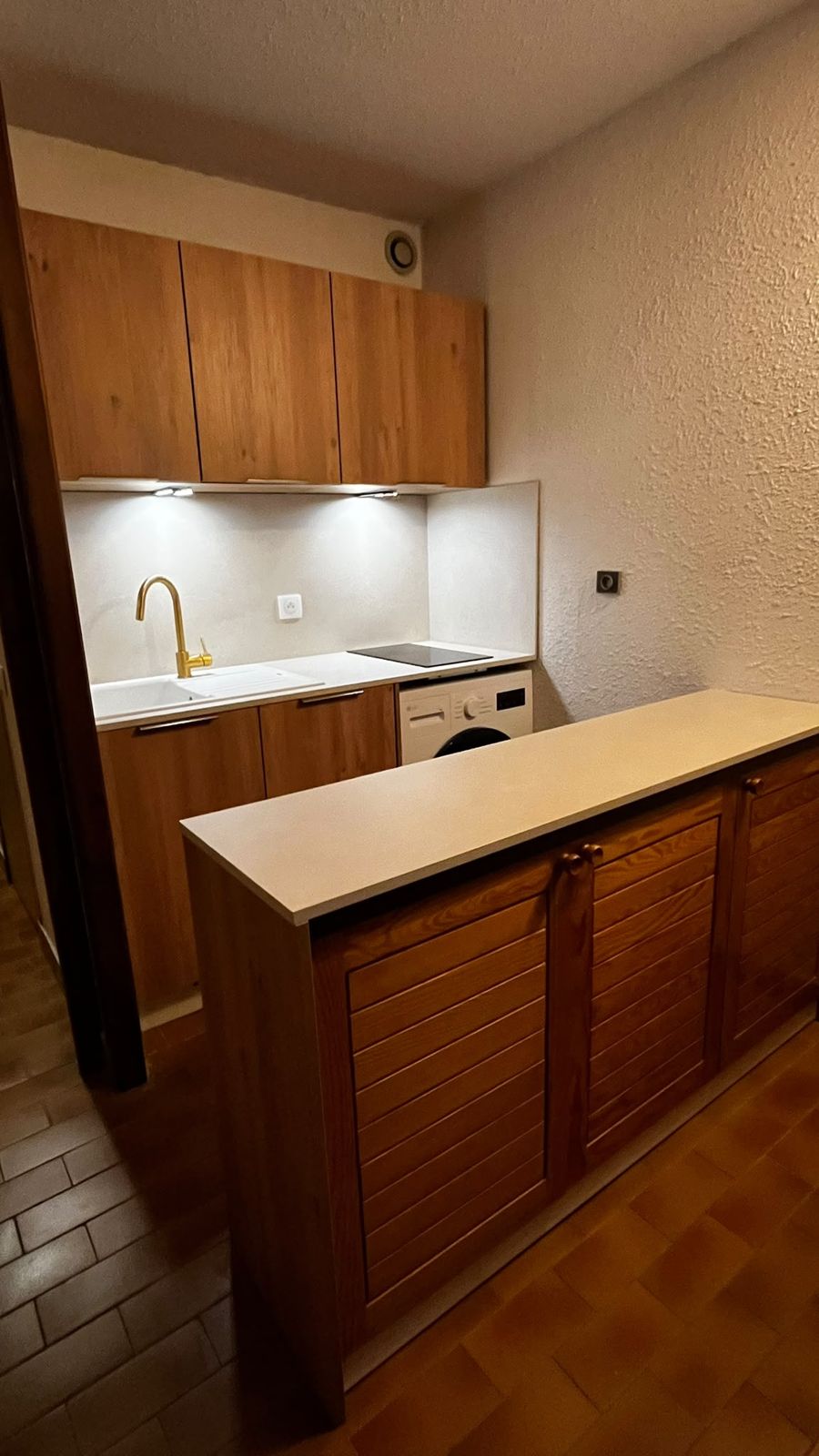 Cuisine rénovée avec plaque induction, lave-linge et comptoir